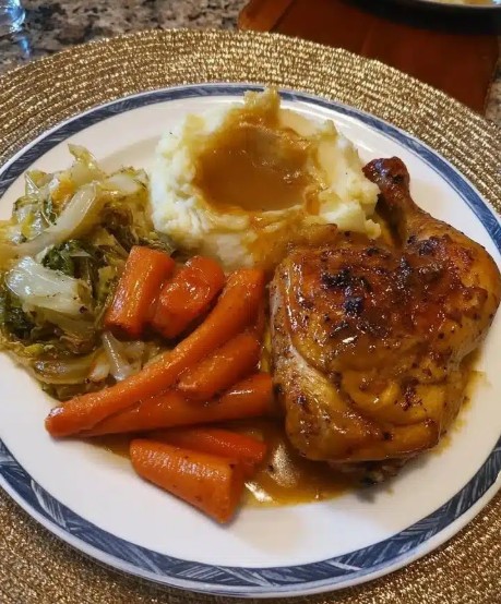Herb chicken dinner with mashed potatoes gravy carrots and cabbage